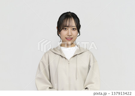 カメラ目線で微笑む若い女性　白背景ポートレート 137913422