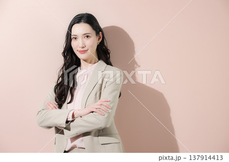 かわいいスーツの日本人女性のカメラ目線の笑顔　多幸感や成功や自信あふれる春色ビジネスイメージ　ピンク 137914413