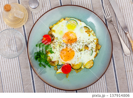 Close up of cooked eggs with zucchini at plate on table 137914806