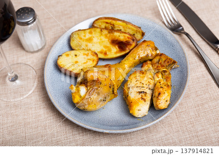 Delicious baked chicken legs with garnish of boiled potatoes Delicious baked chicken legs with garnish of boiled potatoes 137914821