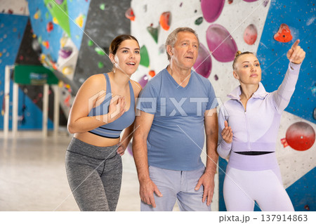 Sports women and man are actively discussing the successes and mistakes of other athletes on mountaineering simulator 137914863