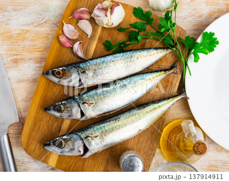 Delicious raw sardine with herbs on kitchen board closeup 137914911