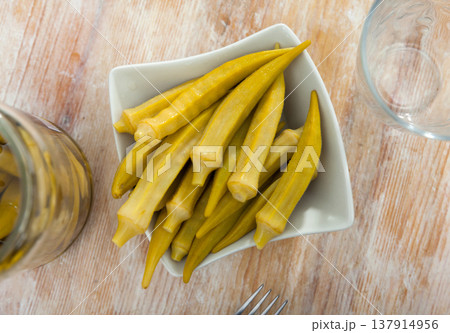 Pickled okra pods on plate, homemade preserves 137914956