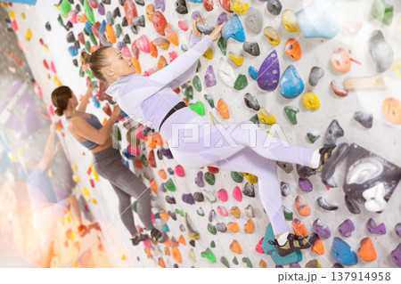 Woman training at bouldering gym without special climbing equipment Woman training at bouldering gym without special climbing equipment 137914958