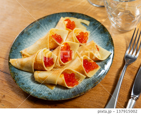 Tasty russian pancakes with red caviar at plate Tasty russian pancakes with red caviar at plate 137915002