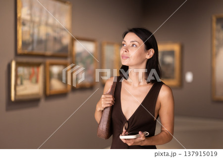 Brunette with phone in hand came to the art gallery 137915019