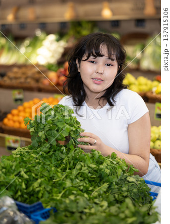 Young asian girl hoosing fresh greens in farm store Young asian girl hoosing fresh greens in farm store 137915106
