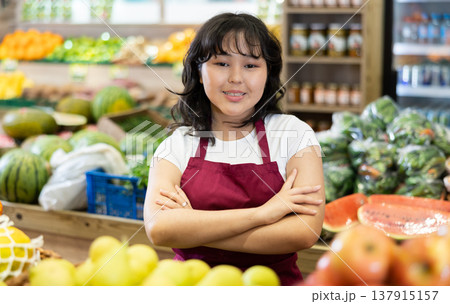 Confident successful young asian salesgirl standing in greengrocery 137915157