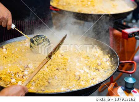 Preparation of Catalan seafood fideua in paellera on street festival Preparation of Catalan seafood fideua in paellera on street festival 137915162