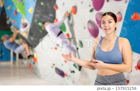 Cheerful sporty young girl inviting to workout in climbing center 137915256