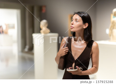 Young woman at a sculpture exhibition 137915288
