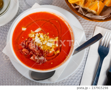 There is large portion of soup salmorejo cordoba decorated with hill of ham and egg chips There is large portion of soup salmorejo cordoba decorated with hill of ham and egg chips 137915298