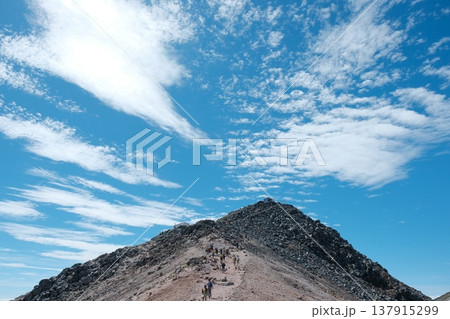 青空に向かって登る乗鞍岳・剣ヶ峰の登山風景 137915299