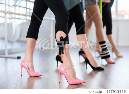 Female legs in sportswear and high heels performing graceful walk of stiletto dance 137915336