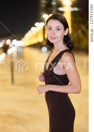 Woman walking along coastal promenade at night in Barcelona 137915388