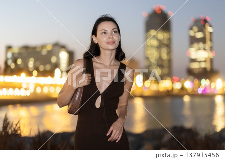 Young woman standing at seaside against background of twin towers Young woman standing at seaside against background of twin towers 137915456