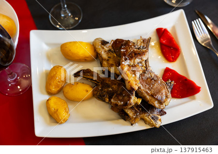 Fried lamb served with potatoes and peppers 137915463