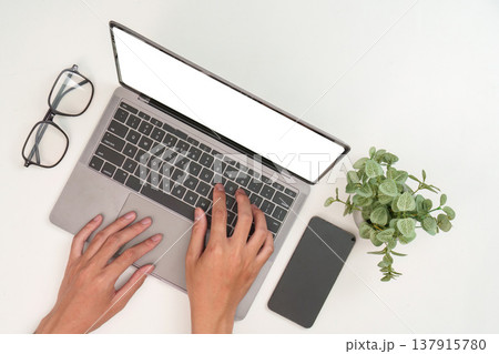Hands typing on laptop in modern workspace 137915780