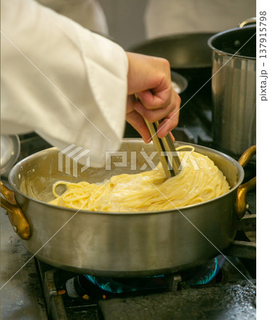キッチンでパスタを調理するシェフの手元 キッチンでパスタを調理するシェフの手元 137915798