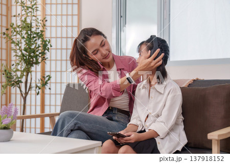 Mother helping daughter with headphones Mother helping daughter with headphones 137918152