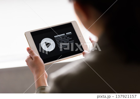 タブレットで動画を視聴する女性 タブレットで動画を視聴する女性 137921157