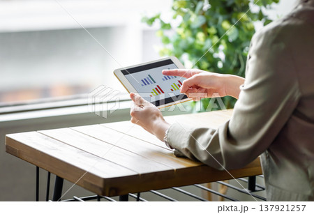 タブレットで業績グラフをチェックする様子 タブレットで業績グラフをチェックする様子 137921257