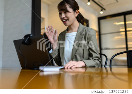 オンライン会議で笑顔で手を振る女性 オンライン会議で笑顔で手を振る女性 137921285