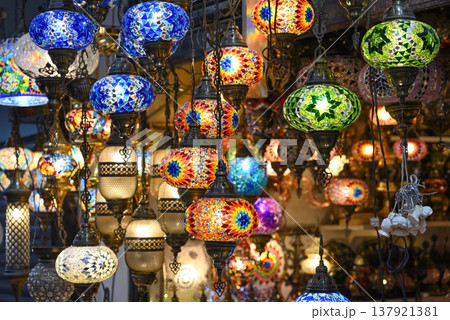 A colorful collection of intricately patterned mosaic glass lanterns hangs in a market A colorful collection of intricately patterned mosaic glass lanterns hangs in a market 137921381