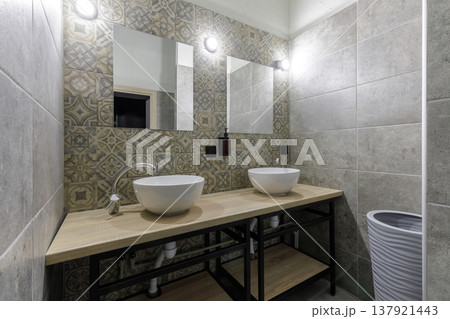 Modern Hostel Bathroom with Double Vessel Sinks and Patterned Tiles Modern Hostel Bathroom with Double Vessel Sinks and Patterned Tiles 137921443