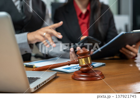 Teamwork of business lawyer meeting working hard about legal legislation in courtroom to help their customer. Teamwork of business lawyer meeting working hard about legal legislation in courtroom to help their customer. 137921745