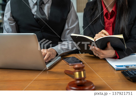 Teamwork of business lawyer meeting working hard about legal legislation in courtroom to help their customer. Teamwork of business lawyer meeting working hard about legal legislation in courtroom to help their customer. 137921751