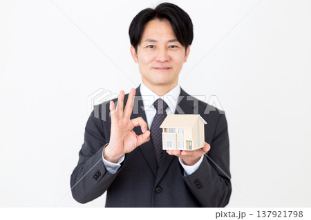 一戸建ての住宅模型を持って丸のポーズをするミドル男性ビジネスマン 一戸建ての住宅模型を持って丸のポーズをするミドル男性ビジネスマン 137921798