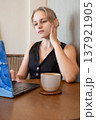 Casual focused business woman using laptop and freelancing in bright cafe environment 137921905