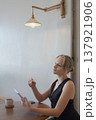 Casual young business woman using digital tablet while sitting at table in cafe 137921906