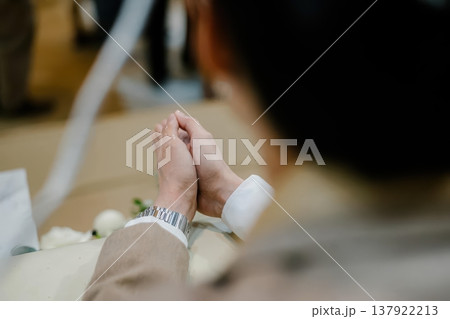 Close-up of Man's Hands Clasped in Prayer During a Wedding Ceremony Close-up of Man's Hands Clasped in Prayer During a Wedding Ceremony 137922213
