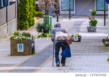 日本の横浜都市景観坂道が続く街…木製のベンチ…高齢化社会。杖の高齢女性…人生とは…＝横浜市内 137923456
