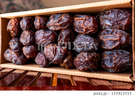 A close-up of two plates containing dates and walnuts, accompanied by cinnamon sticks prepared for Iftar at Ramadan. The scene highlights healthy snacks and natural ingredients. A close-up of two plates containing dates and walnuts, accompanied by cinnamon sticks prepared for Iftar at Ramadan. The scene highlights healthy snacks and natural ingredients. 137923555