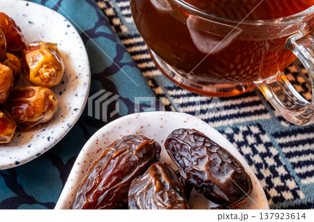 A close-up of two plates containing dates and walnuts, accompanied by cinnamon sticks prepared for Iftar at Ramadan. The scene highlights healthy snacks and natural ingredients. A close-up of two plates containing dates and walnuts, accompanied by cinnamon sticks prepared for Iftar at Ramadan. The scene highlights healthy snacks and natural ingredients. 137923614