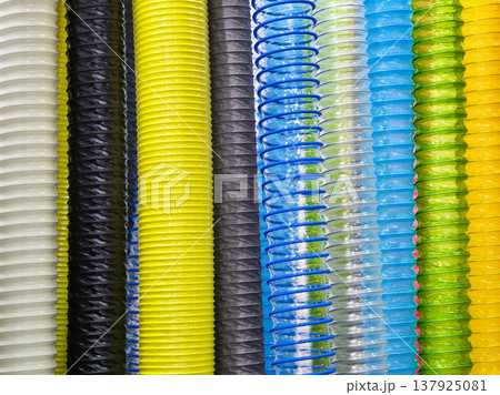 Different colors of plastic spiral tubes arranged vertically in a close view showing various shades and patterns 137925081