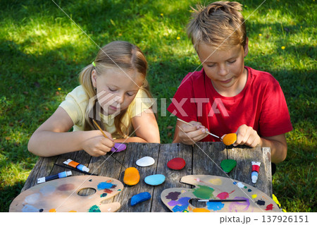 Little painters bring stones to life, expressing their dreams in vivid color to craft special DIY presents. Little painters bring stones to life, expressing their dreams in vivid color to craft special DIY presents. 137926151