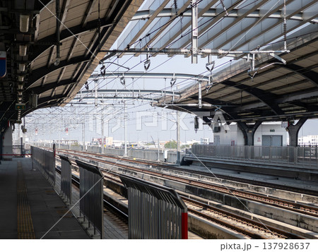 Modern railway station platform with parallel train tracks. Modern railway station platform with parallel train tracks. 137928637
