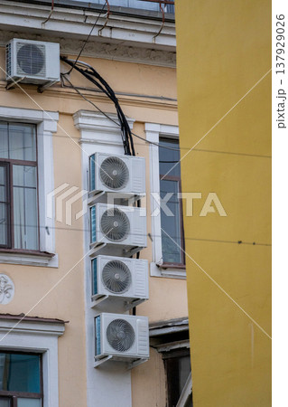 air conditioning on facade of building, air cooling in hot weather. air conditioning on facade of building, air cooling in hot weather. 137929026