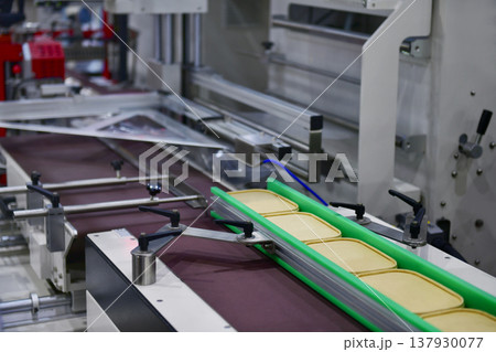 Industrial food packaging line with eco-friendly paper containers in a modern manufacturing factory 137930077