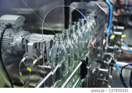 Conveyor belt with empty glass bottles in a modern bottling factory line 137930281