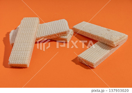 Stacked vanilla wafers on orange background 137933020