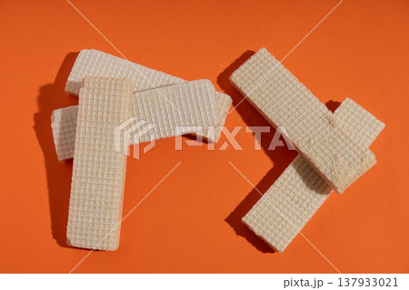 Crispy wafer cookies stacked on orange background 137933021