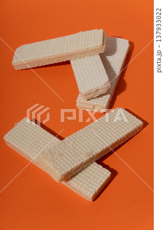 Vanilla wafers on orange background, creating sweet dessert snack 137933022