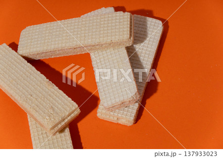Crisp wafer cookies on vibrant orange background Crisp wafer cookies on vibrant orange background 137933023