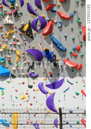 ボルダリングで壁を登る選手 137933183