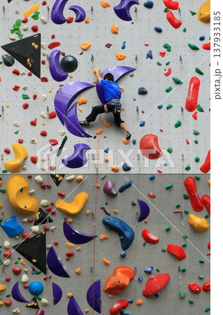 ボルダリングで壁を登る選手 137933185